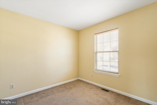 empty room featuring light carpet, baseboards, and visible vents