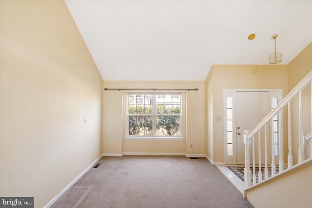 entryway featuring lofted ceiling, baseboards, light carpet, and stairway