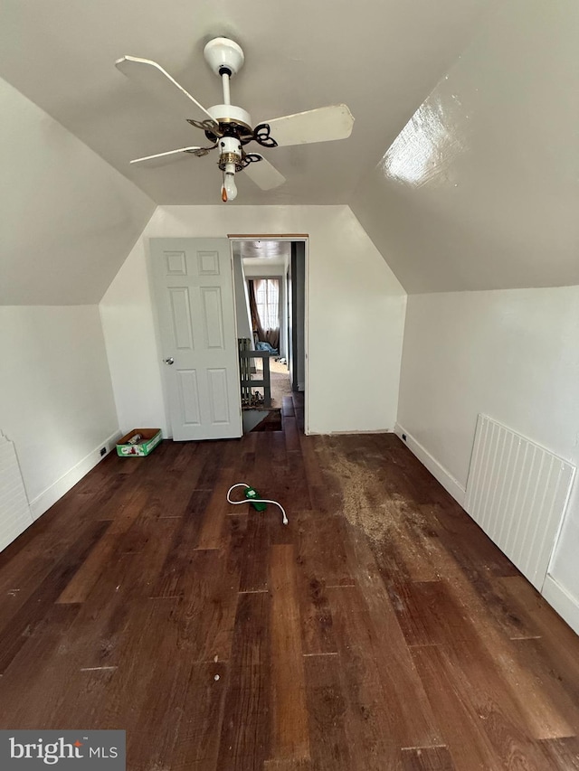 additional living space with lofted ceiling, ceiling fan, baseboards, and dark wood finished floors