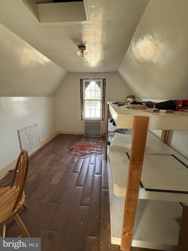 additional living space with vaulted ceiling, baseboards, dark wood finished floors, and a textured ceiling