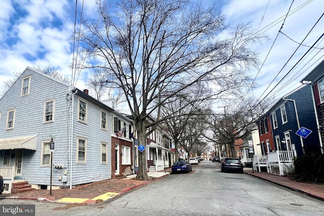 view of street featuring a residential view, curbs, and sidewalks