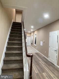 stairs featuring baseboards, wood finished floors, and recessed lighting