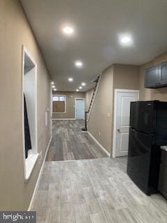 hallway with stairs, baseboards, light wood-style flooring, and recessed lighting