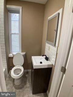 bathroom featuring vanity, toilet, and baseboards