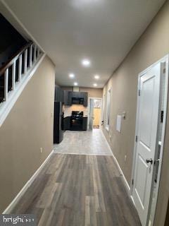 hall featuring recessed lighting, dark wood finished floors, and baseboards