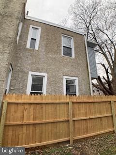 view of home's exterior with fence and stucco siding