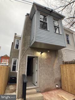 back of house with entry steps, fence, and a chimney