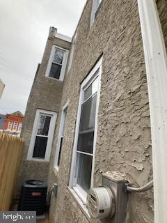 view of side of home with fence and central AC unit