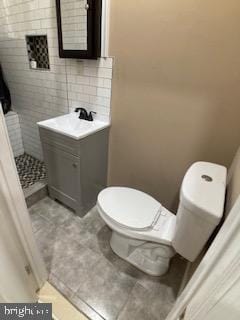 bathroom featuring decorative backsplash, tile patterned flooring, vanity, and toilet