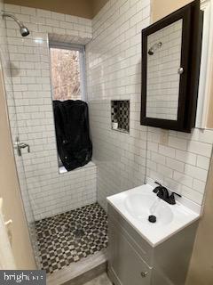 bathroom with a shower stall and vanity