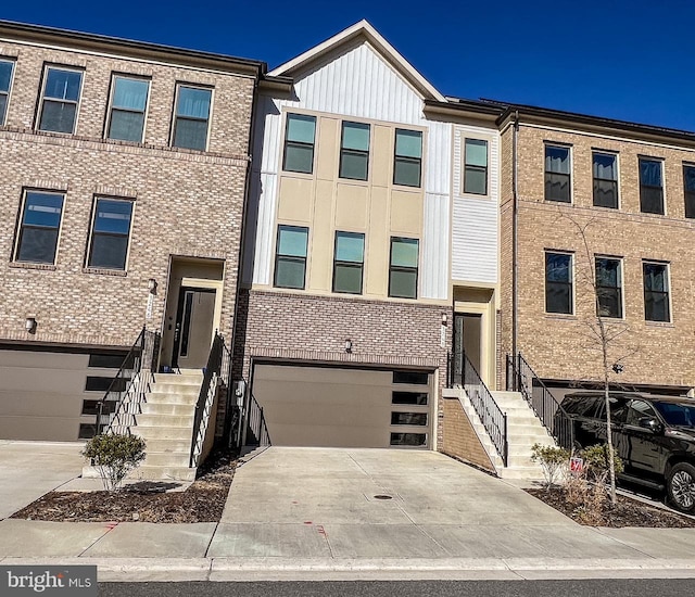 multi unit property featuring a garage, concrete driveway, and brick siding