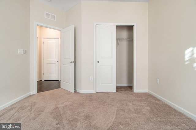 unfurnished bedroom featuring baseboards, visible vents, and carpet flooring