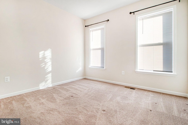 carpeted spare room with baseboards and visible vents