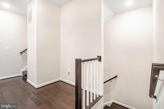 stairway featuring visible vents, baseboards, and wood finished floors