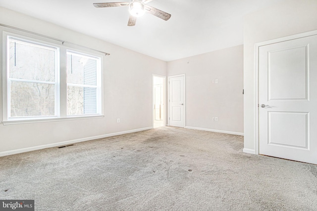 spare room featuring a ceiling fan, carpet, visible vents, and baseboards