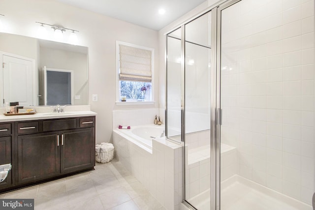 bathroom with vanity, a stall shower, tile patterned flooring, and a bath