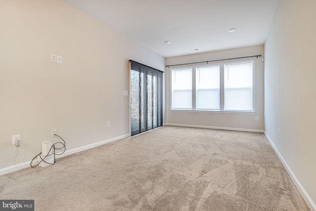 carpeted spare room with baseboards