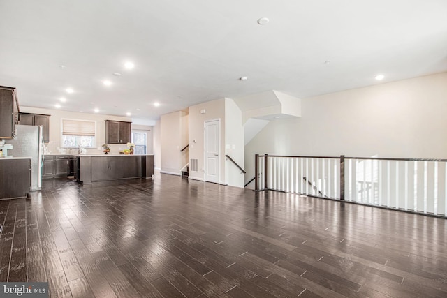 unfurnished living room featuring dark wood-type flooring and recessed lighting