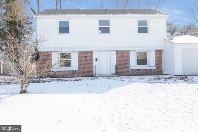 view of front of home with brick siding and a garage