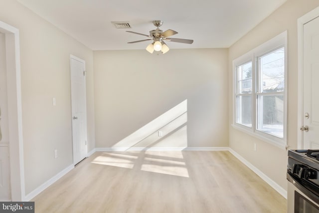 unfurnished room featuring visible vents, light wood-style flooring, and baseboards