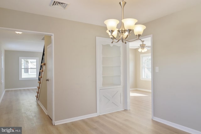 interior space featuring a notable chandelier, visible vents, baseboards, light wood-style floors, and stairway