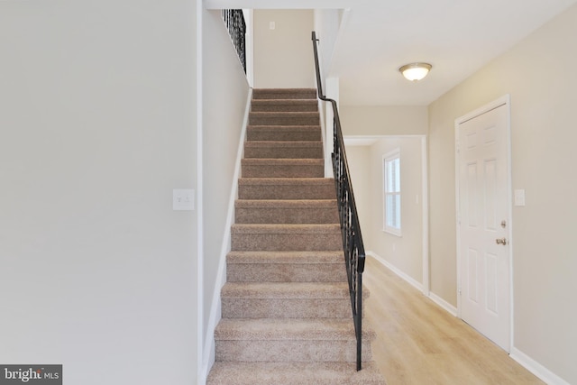 staircase with wood finished floors and baseboards