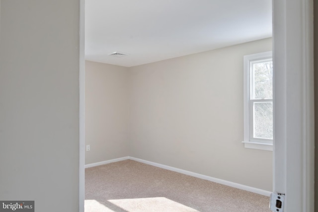 empty room with light carpet, visible vents, and baseboards