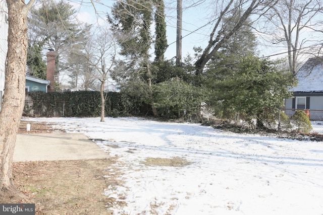 yard layered in snow featuring fence