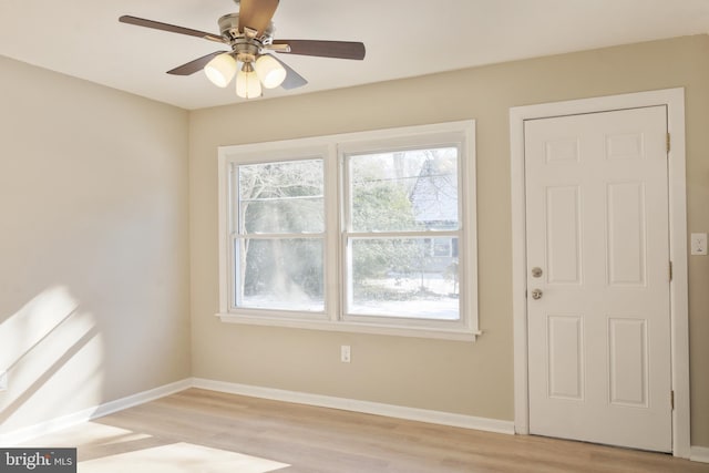 interior space featuring light wood-style floors, ceiling fan, and baseboards