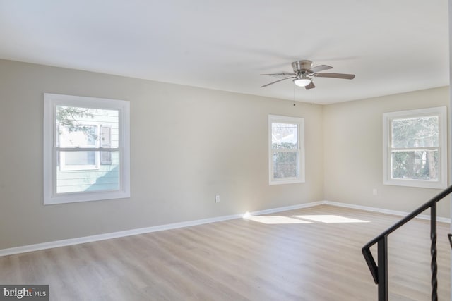 unfurnished room featuring light wood finished floors, ceiling fan, and baseboards