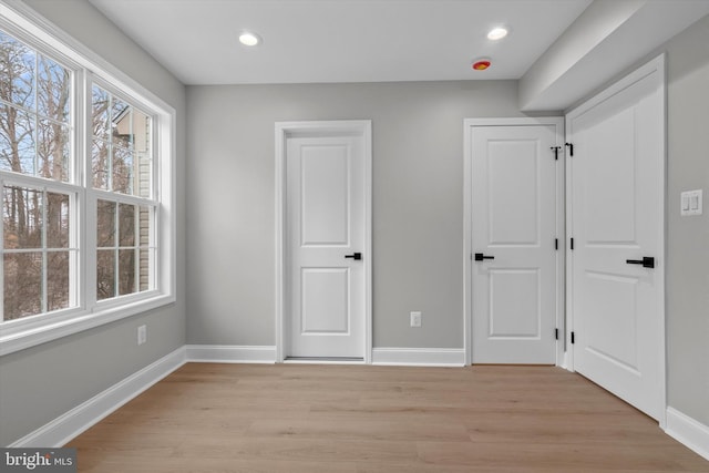 unfurnished bedroom featuring light wood-style floors, recessed lighting, and baseboards