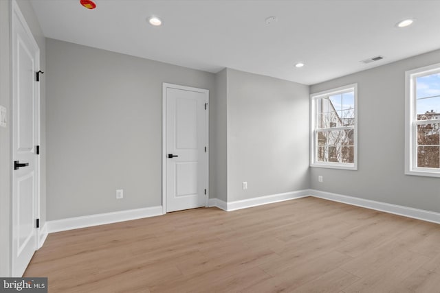 unfurnished bedroom with light wood-type flooring, visible vents, baseboards, and recessed lighting