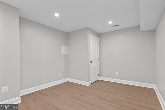 empty room featuring light wood-type flooring, visible vents, baseboards, and recessed lighting