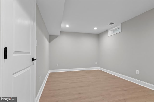 finished below grade area with light wood-style floors, visible vents, baseboards, and recessed lighting