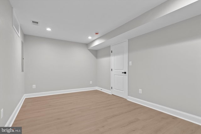 finished below grade area with recessed lighting, visible vents, light wood-style flooring, and baseboards