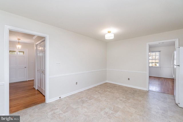 spare room featuring baseboards and light wood finished floors