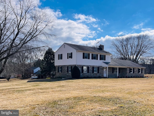 colonial house with a front lawn and a chimney