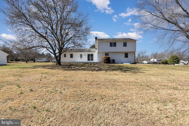 back of property with a yard and a chimney