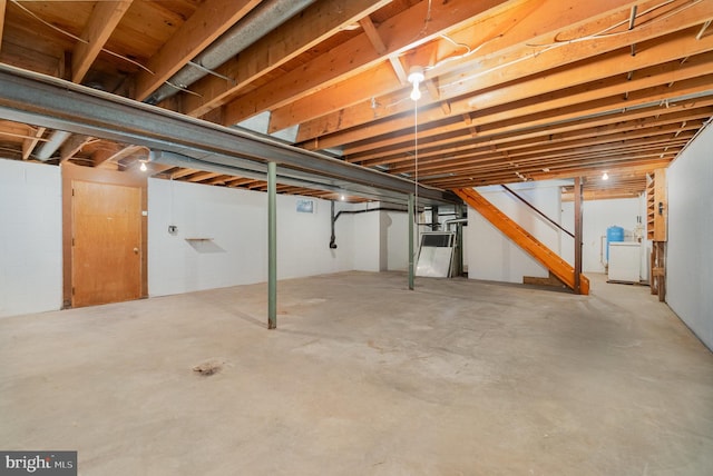 unfinished below grade area featuring washer / dryer and stairway