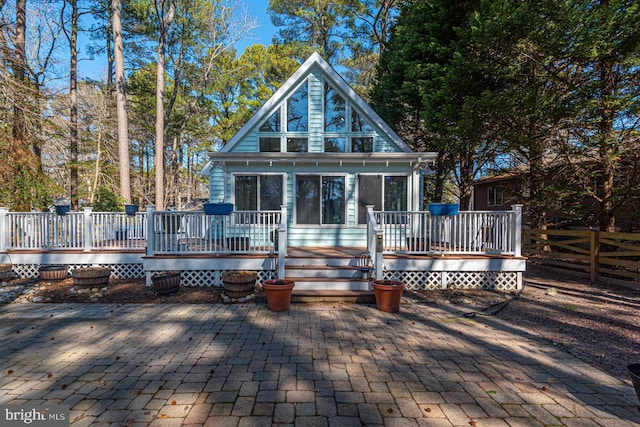 rear view of house featuring a deck, a patio, and fence