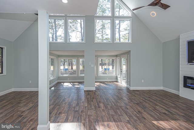 unfurnished living room with a fireplace, baseboards, and dark wood finished floors