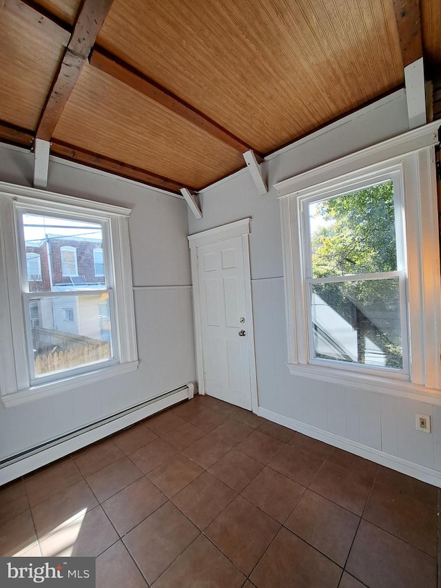 empty room featuring dark tile patterned flooring, beamed ceiling, a baseboard radiator, and wood ceiling