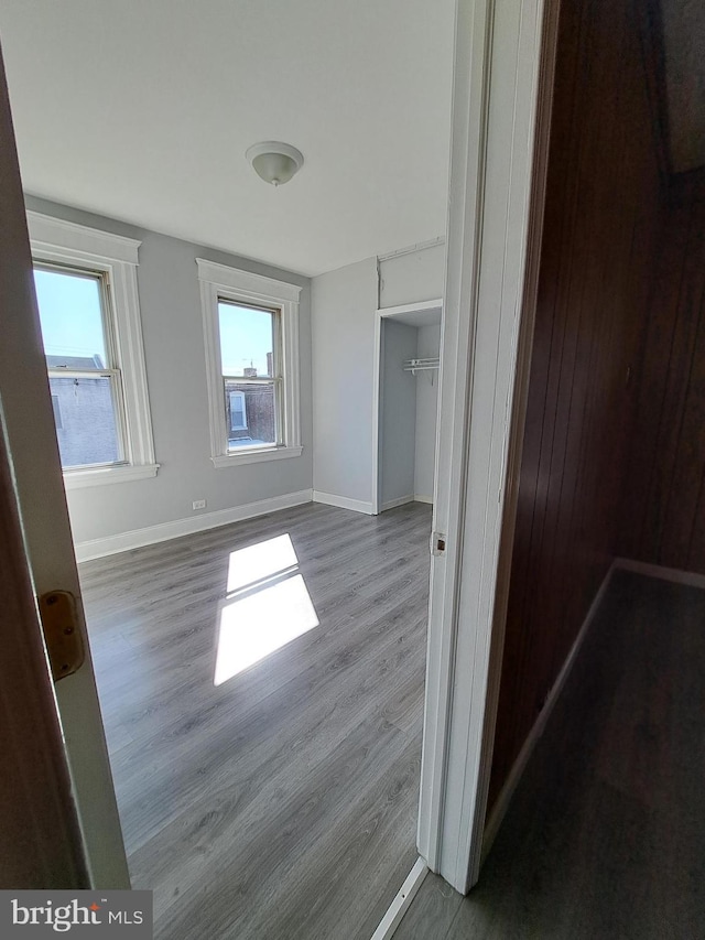 unfurnished bedroom featuring light wood-style floors, a closet, and baseboards