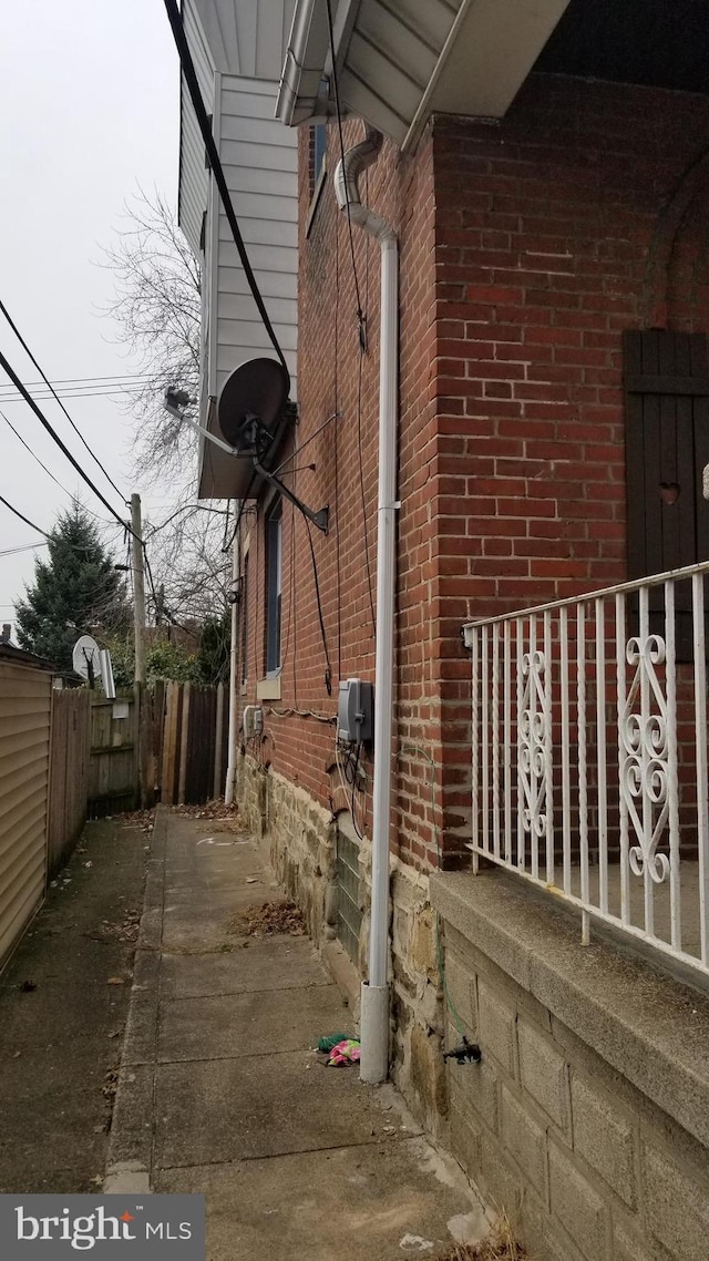 view of home's exterior featuring brick siding and fence