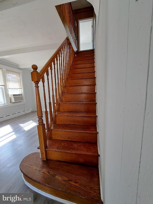 stairway featuring arched walkways, a baseboard radiator, and wood finished floors