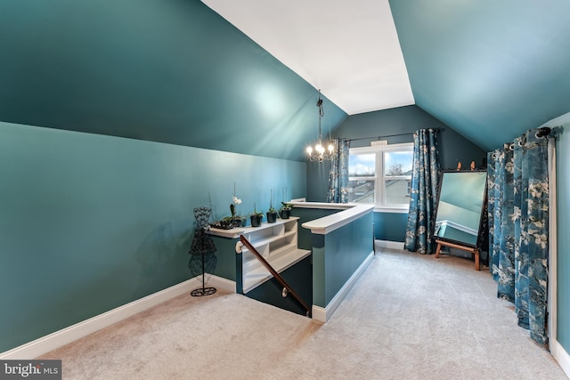 interior space featuring baseboards, vaulted ceiling, and a notable chandelier