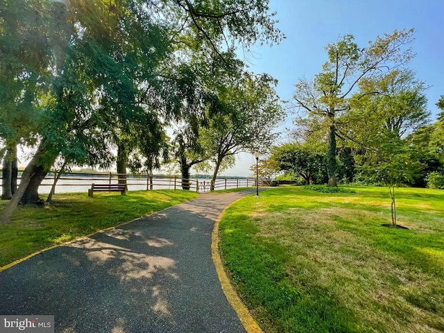 view of property's community with a lawn and fence