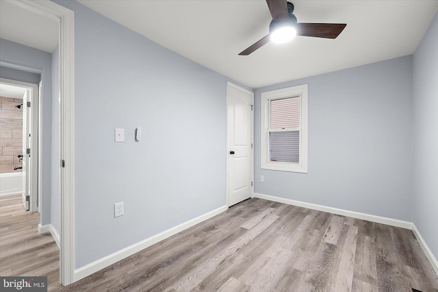 unfurnished bedroom with ceiling fan, wood finished floors, and baseboards