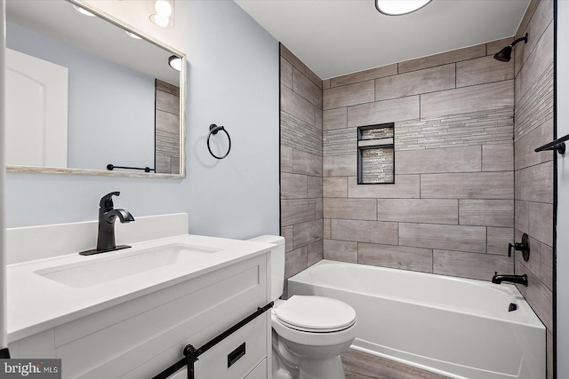 full bath with wood finished floors, bathing tub / shower combination, vanity, and toilet