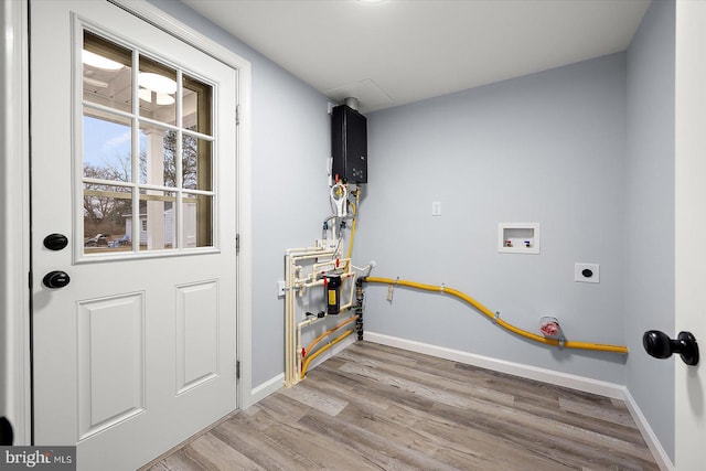 clothes washing area featuring hookup for a washing machine, hookup for an electric dryer, wood finished floors, laundry area, and baseboards